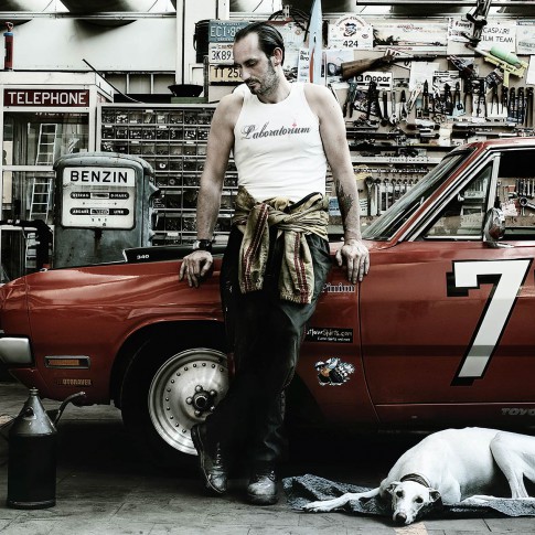 Transportation - Mann mit Hund vor Cadillac in Werkstatt