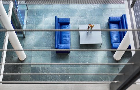 Architektur--Blick-von-oben-auf-blaue-Sofas-auf-mintgruenem-Steinboden--Bankgebaeude